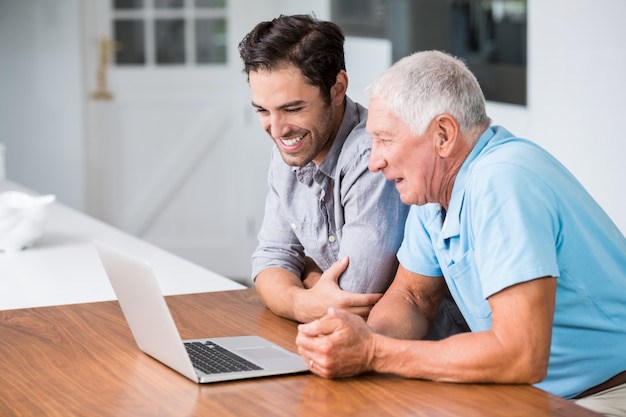 Sourire père et fils à l'aide d'un ordinateur portable