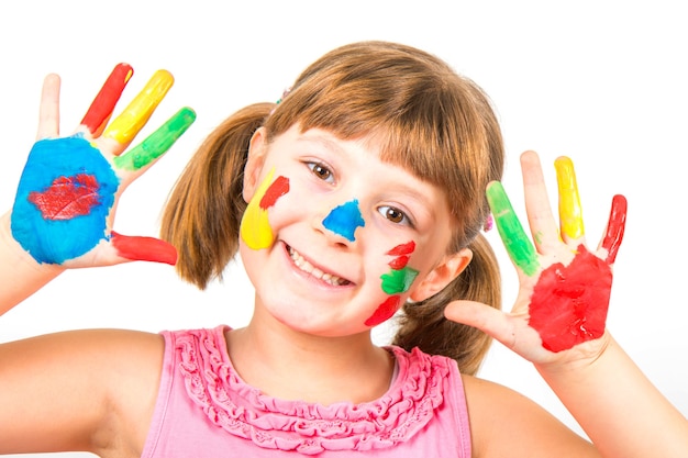 Sourire de petite fille aux mains peintes dans des peintures colorées