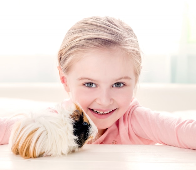 Sourire, petite fille, étreindre, cochon inde