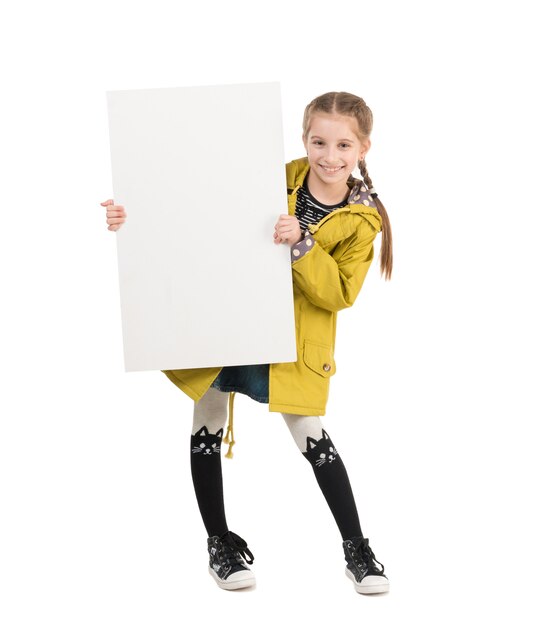 Sourire de petite fille avec une feuille vierge dans les mains