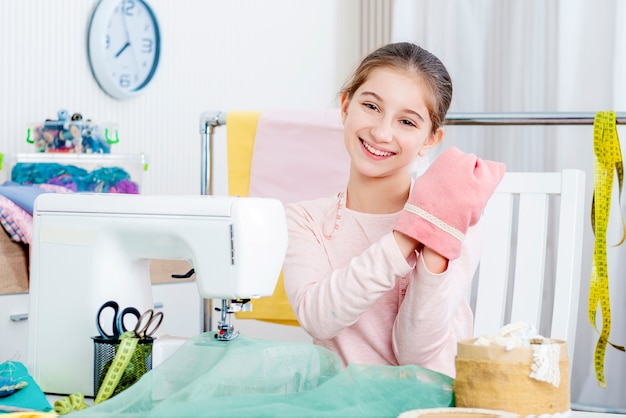 Sourire de petite fille travaillant à la machine à coudre