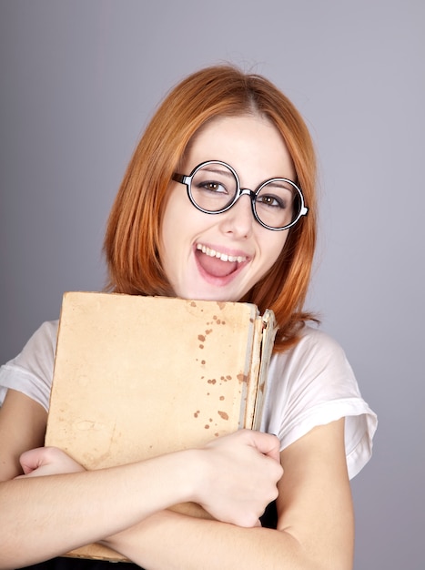 Sourire rousse avec vieux livre.