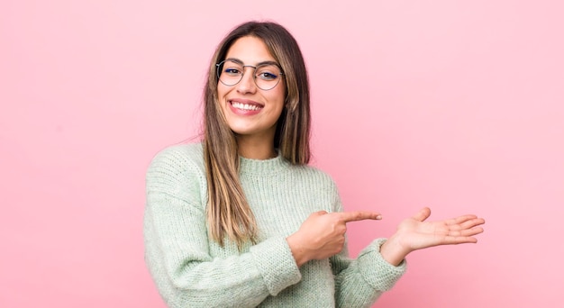 Sourire, se sentir heureux, insouciant et satisfait, pointant vers un concept ou une idée sur l'espace de copie sur le côté