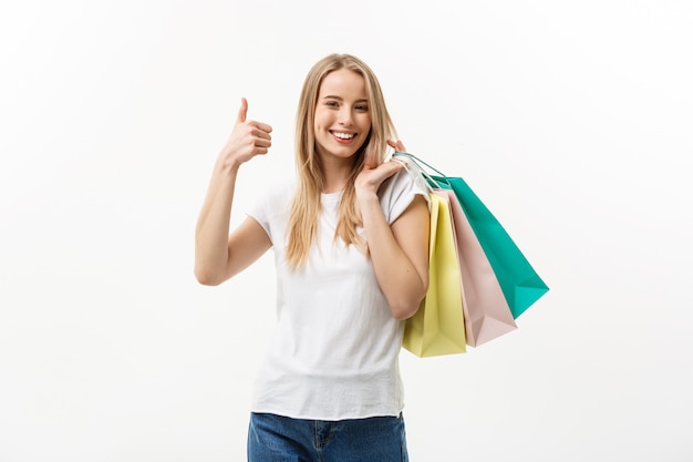 Sourire, séduisant, femme, tenue, sacs provisions, faire, pouce haut, signe, blanc