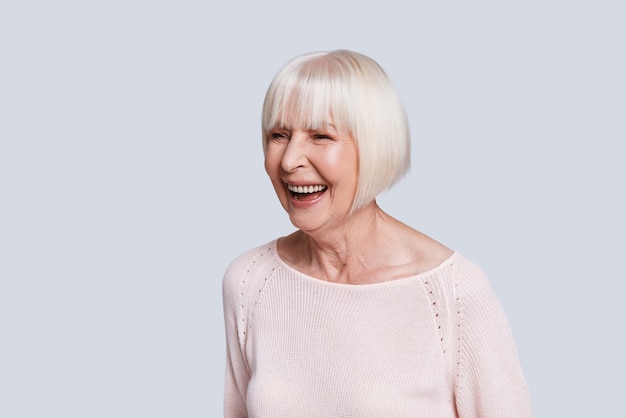 Sourire sincère. Belle femme âgée regardant loin et souriant