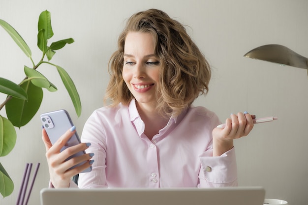 Photo sourire de vidéoconférence de jeune femme d'affaires appelant sur un téléphone intelligent parler par webcam dans le chat en ligne, service de support client et concept d'enseignement en ligne à distance. travail à distance