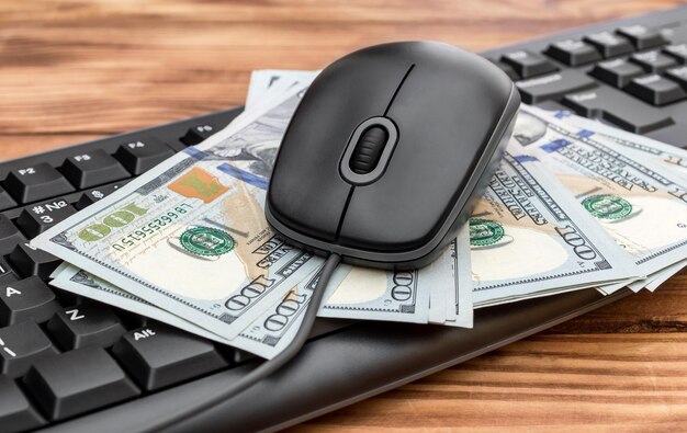 Photo souris et clavier d'ordinateur avec de l'argent sur la table en bois