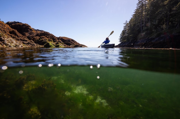 Sur et sous photo d'une femme aventureuse en kayak dans l'océan Pacifique