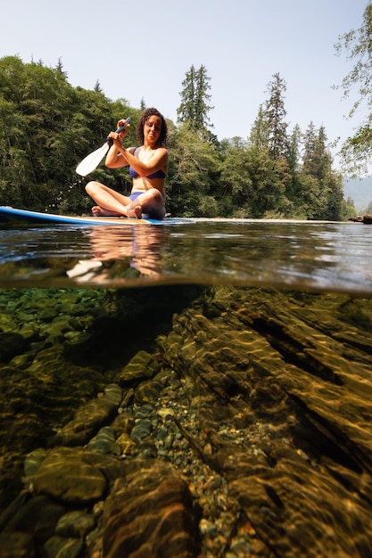 Sur et sous photo d'une femme faisant du paddle dans une rivière