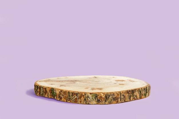 Un sous-verre rond en bois avec une surface texturée et un fond violet.