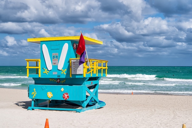 South Beach, Miami, Floride, maison de maître nageur dans un style Art déco coloré sur ciel bleu nuageux et océan Atlantique en arrière-plan, lieu de voyage de renommée mondiale