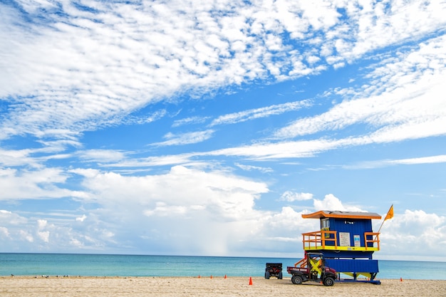 South Beach, Miami, Floride, maison de maître nageur dans un style Art déco coloré sur ciel bleu nuageux et océan Atlantique en arrière-plan, lieu de voyage de renommée mondiale