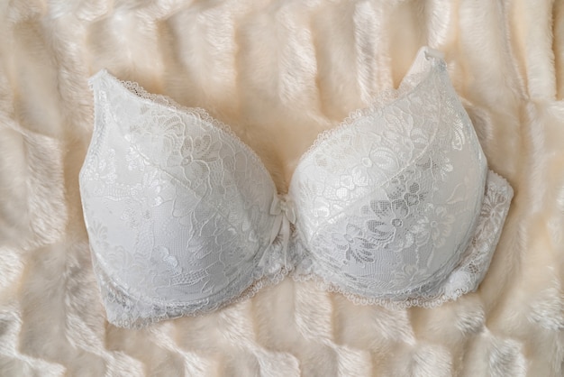 Photo soutien-gorge féminin séduisant sur tissu beige, gros plan