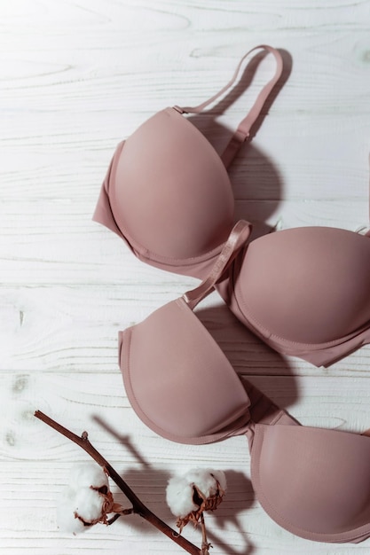 Soutien-gorge rose avec brunch en coton sur fond de bois blanc gros plan