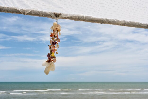 Souvenir de coquillage décoration suspendue sur belvédère en bois avec plage tropicale aux beaux jours