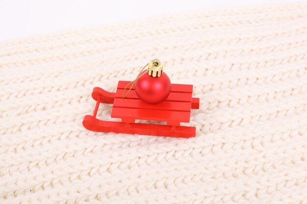 Souvenir de Noël de traîneau en bois rouge sur le textile blanc