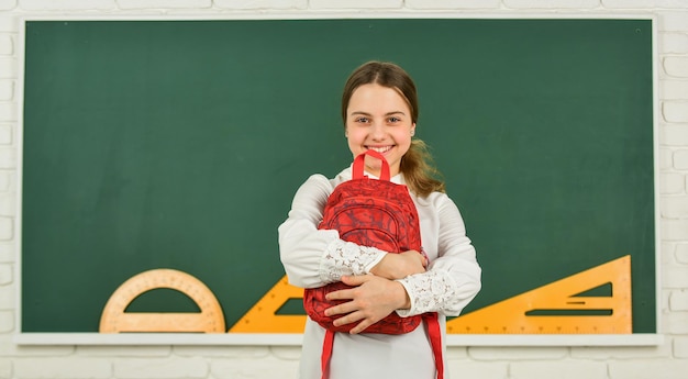 Souvenirs d'enfance. fille heureuse porter un sac à dos au tableau noir. classe de cours de mathématiques. enfant adolescent hipster intelligent. petit enfant prêt à étudier. touriste ou étudiant. voyager pour étudier à l'étranger. Retour à l'école.