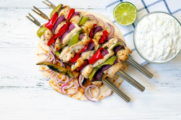 Photo souvlaki de poulet grillé à la grecque traditionnelle avec sauce tzatziki et pain pita