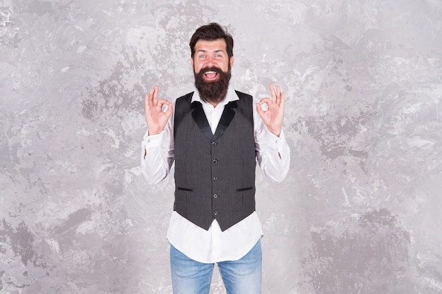 Soyez OK aujourd'hui. Un hipster heureux avec moustache et barbe montre des signes OK. Homme barbu souriant avec des gestes de la main OK. C'est bien de se sentir heureux.