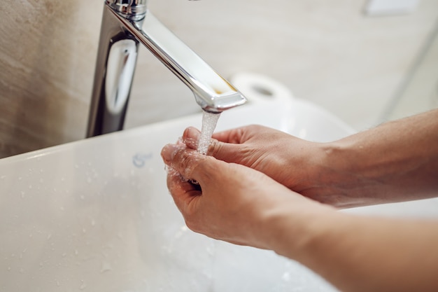 Soyez responsable et lavez-vous les mains. Se laver les mains dans la salle de bain. Pandémie mondiale.