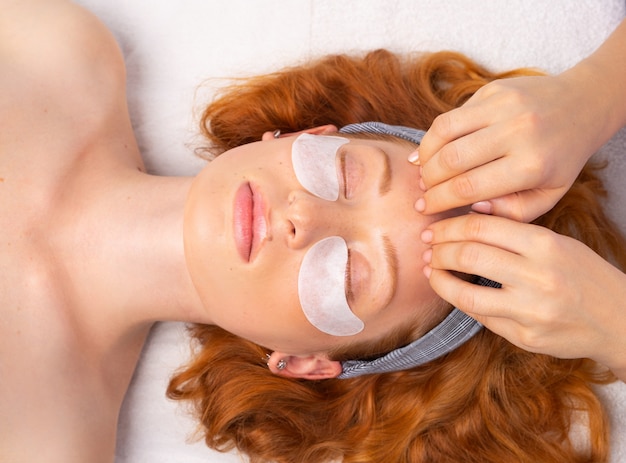 Spa. Après avoir appliqué le masque transparent, l'esthéticienne fait un massage du visage. Le concept d'une peau saine, hydratée et soignée.