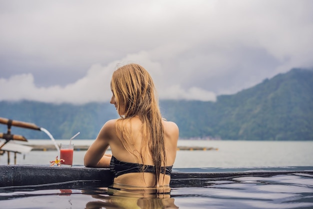 Spa géothermique Femme se relaxant dans une piscine thermale contre le concept de sources chaudes du lac