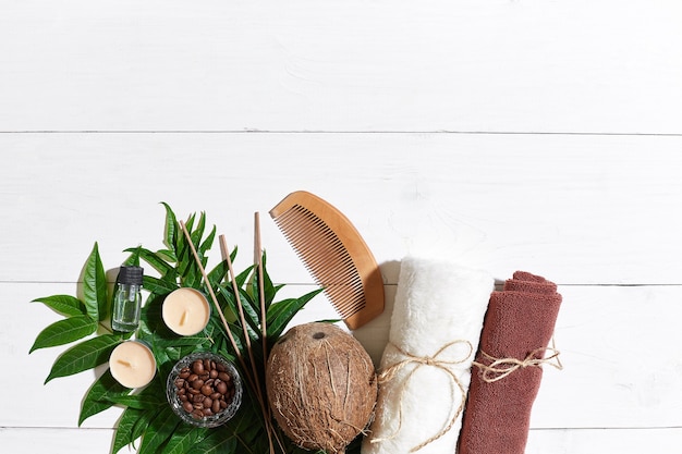 Spa nature morte avec bougies serviette et feuilles vertes sur une surface en bois blanc