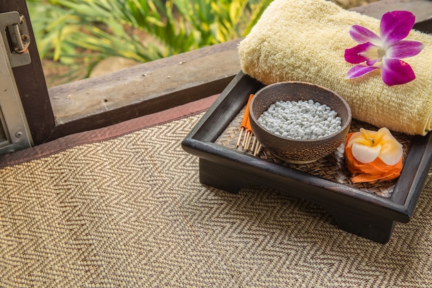 Photo spa set. bougies en forme de fleurs, bâtonnets d'encens dans une boîte orange