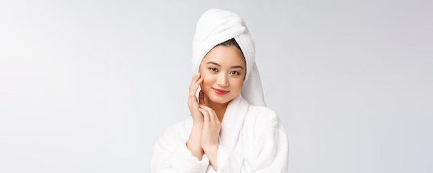 Spa skincare beauté femme asiatique sécher les cheveux avec une serviette sur la tête après le traitement de douche Belle jeune fille multiraciale touchant la peau douce