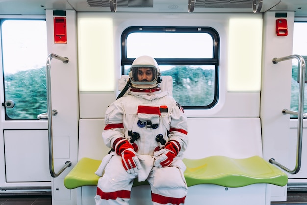 Spaceman dans une station futuriste. Homme avec combinaison spatiale partant pour le travail et prenant le train