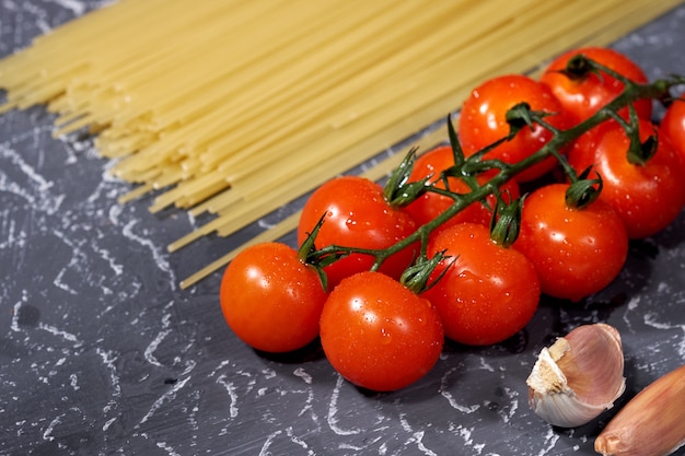 Spaghetti à l&#39;ail, tomates, sur fond gris