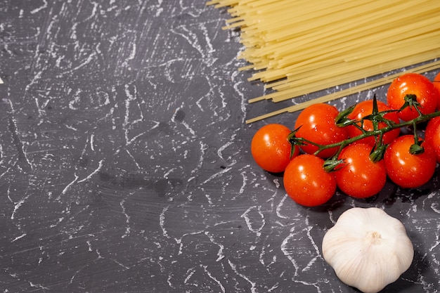 Spaghetti à l&#39;ail, tomates, sur fond gris