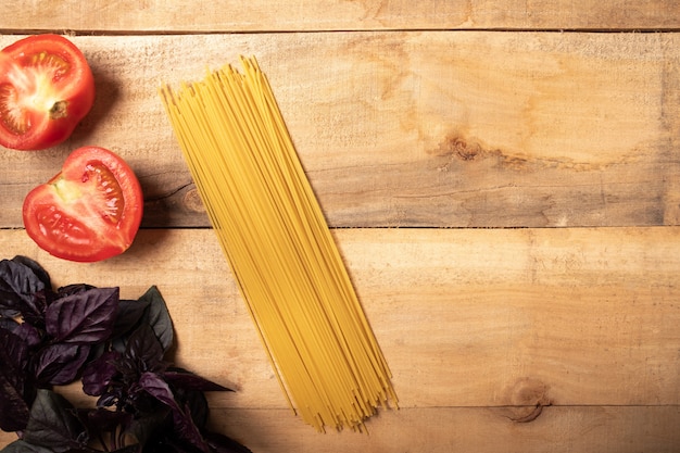 Spaghetti et basilic sur une table en bois. Ingrédients Pâtes