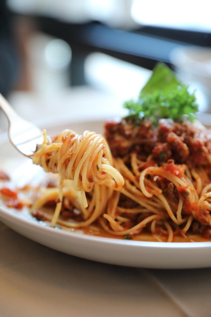 Spaghetti bolognaise au bœuf haché et sauce tomate garnie de parmesan et de basilic, cuisine italienne