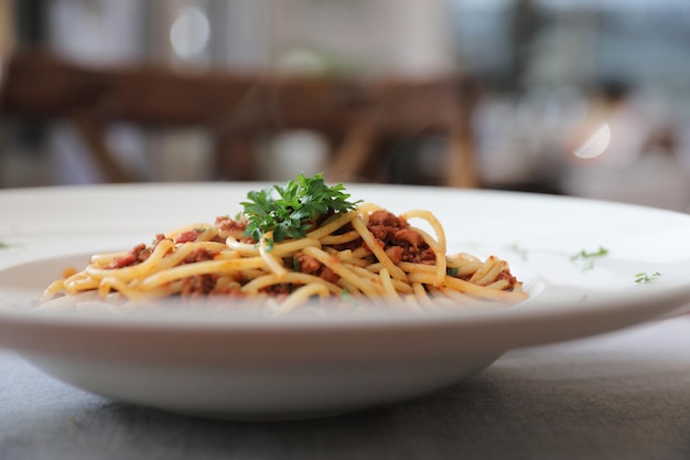 Spaghetti bolognaise avec sauce tometo au boeuf sur table en bois, cuisine italienne