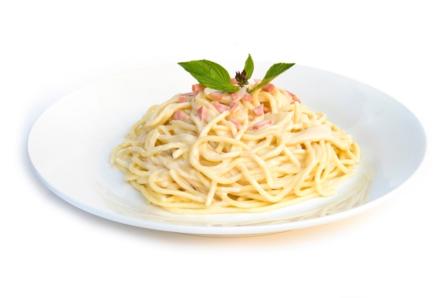 Spaghetti carbonara oignons et champignons sauce au jambon et basilic frais cuisine italienne traditionnelle vue de côté style isolé