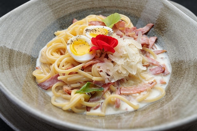 Spaghetti Carbonara sur une plaque sur un fond sombre