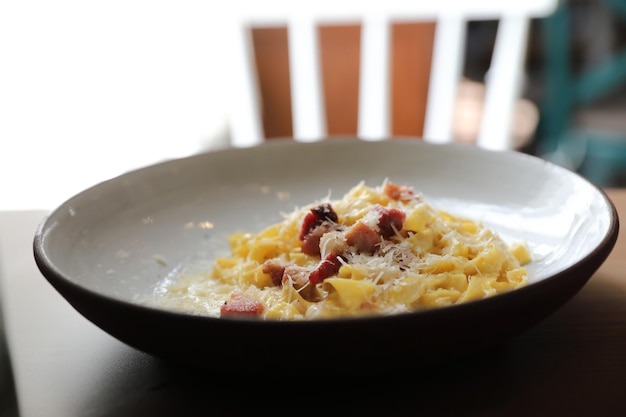 Spaghetti carbonara sauce blanche au bacon sur fond de bois au restaurant