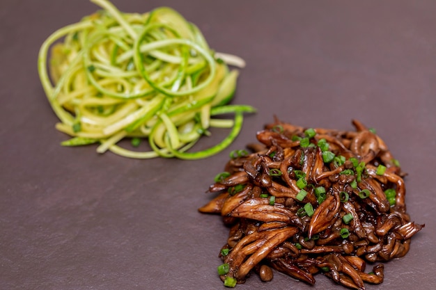 Spaghetti de courgettes au shimeji sur plaque de pierre noire.