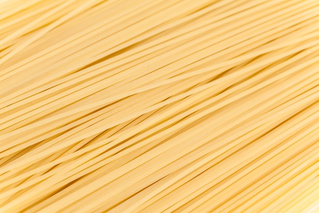 Spaghetti crus sur fond blanc.