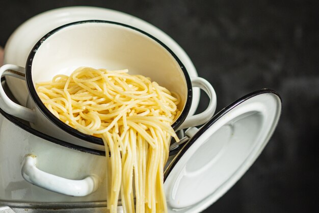 Spaghetti cuit dans une casserole plat italien de blé dur bio, plat sain sur la table