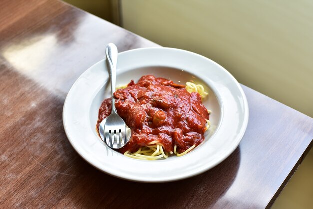 Photo spaghetti dans le plat sur la table en bois