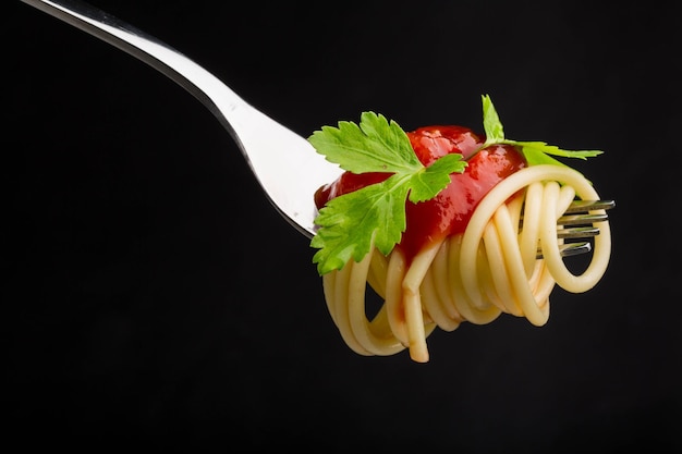 Spaghetti sur une fourchette avec sauce tomate et persil