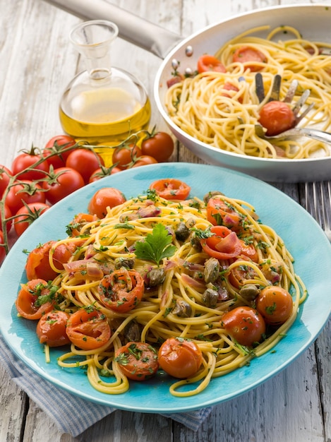 Spaghetti à la guitare avec tomates pachino et câpres