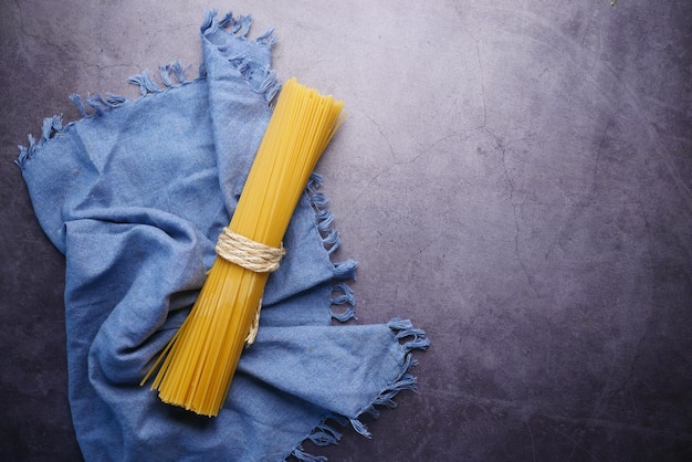 Spaghetti long jaune et une nappe sur fond noir