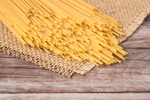 Spaghetti long jaune, spaghetti cru sur fond en bois