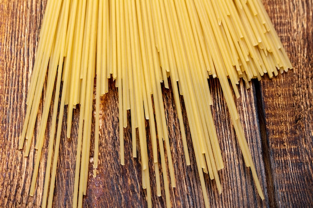 Spaghetti, macaroni, pâtes, linguine blé dur italien mince long sur fond de bois close up selective focus