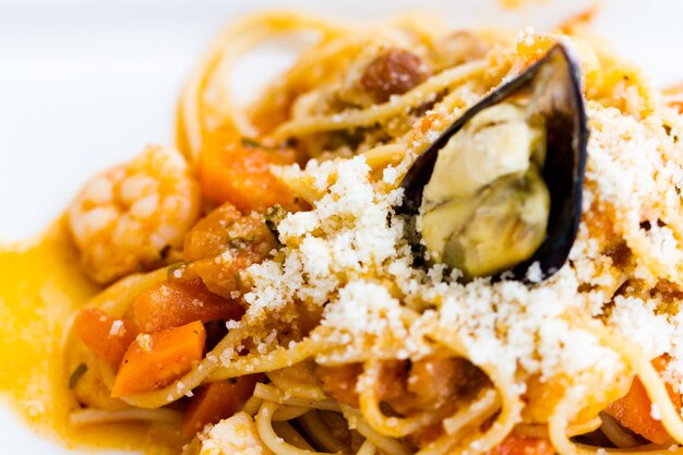 Spaghetti marina servi avec sauce pomodoro aux fruits de mer et mélange de légumes.