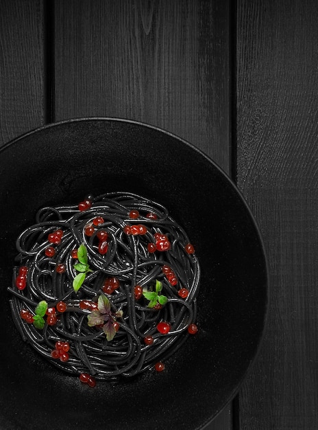 Spaghetti noir avec pâtes au caviar rouge sur fond noir vue de dessus aucun peuple