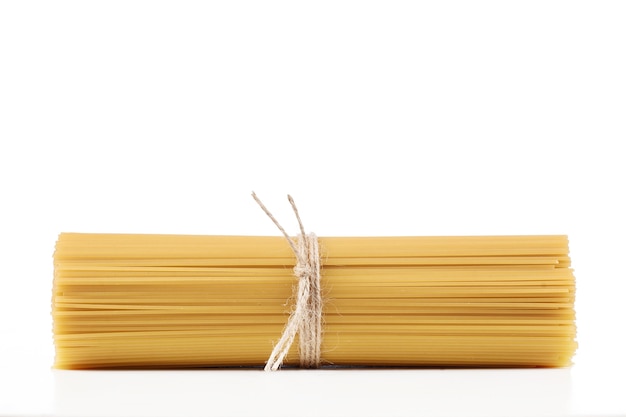 Spaghetti de pâtes sur un blanc, bandé avec fouet